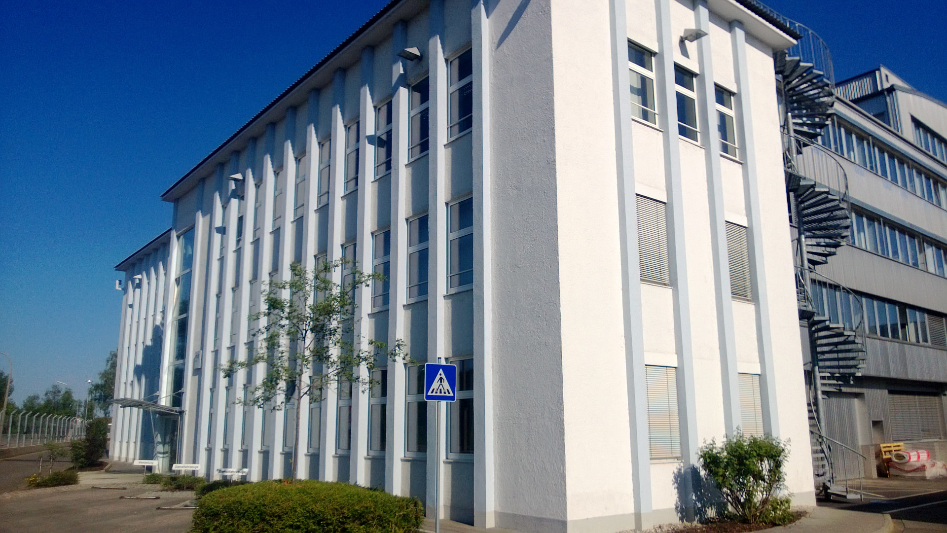 Weiße Fassade eines Verwaltungsgebäudes mit Außentreppe